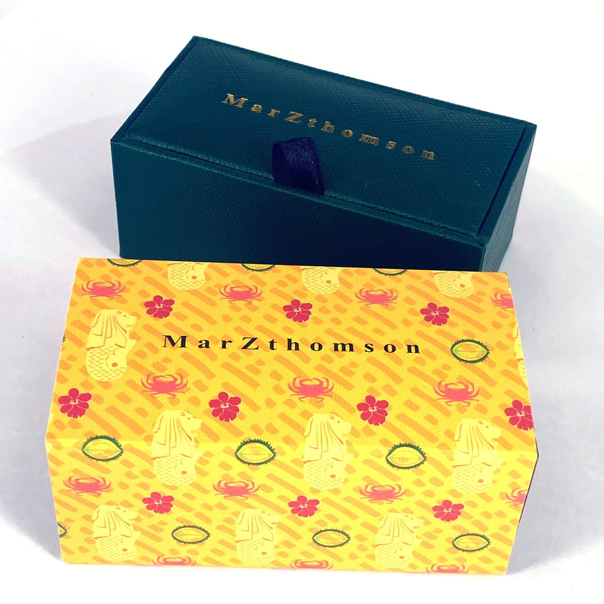 Two boxes with 'MarZthomson' branding, one teal and one yellow with crab pattern.